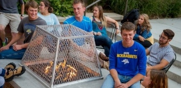 Students sitting around bonfire Students sitting around bonfire
