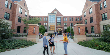 Students in conversing in front of residence halls