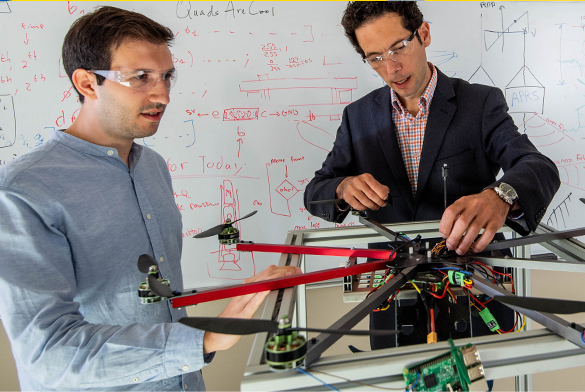Two males working on an engineering project Two males working on an engineering project